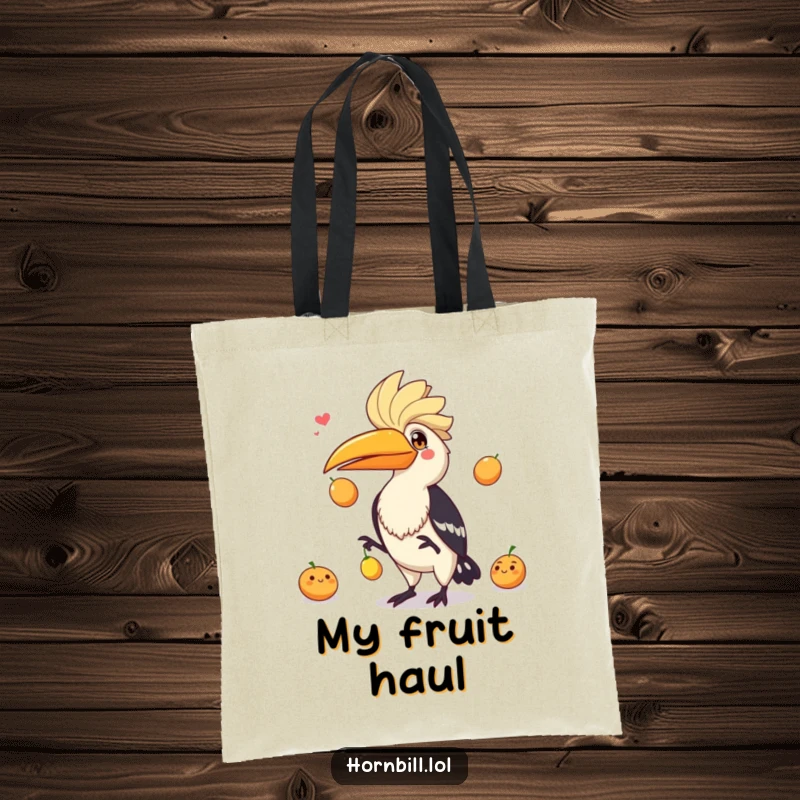 Funny expressive hornbill juggling three small fruits with flair, a lively and humorous addition to this tote bag.